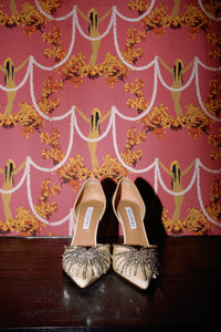 Elegant bridal heels styled against bold wallpaper at Hotel Chelsea in New York City, captured during Japna and Chris’s stylish elopement by NYC wedding photographer Perry Hancock.