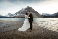 Couple kissing on the shores of bow lake in banff alberta canada