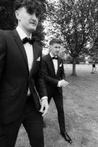 Stylish groom and his best man is walking to the ceremony in perfect suit with black tie