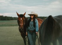 Senior portrait at Triple T Farms in Fruitdale, Alabama — holding the leads of two horses,
wearing a cowboy hat.