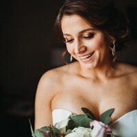 beautiful bride ready for wedding looking at flowers
