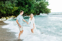 running towards the waves engagement session bride is laughing summer engagement session bleu leake & great vibes