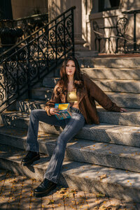A senior from New Berlin West High School sits on a concrete stair case in Downtown Waukesha while reading a book.