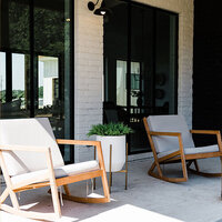 Outdoor patio area with white brick, dark window trim, and patio seating.