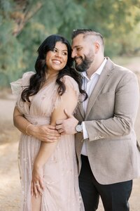 Romantic portrait of the DiLorio family parents smiling and embracing during a golden hour outdoor photography session in Las Vegas.