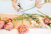 Florist trimming roses for a bouquet during a branding session