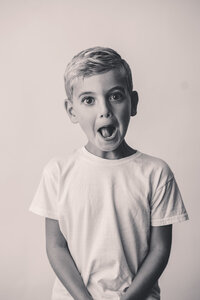 Young boy makes a silly face at the camera during Personality Portrait Photoshoot in Charleston, SC.