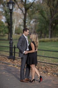 Central park engagement photos, Deborah Zoe Photography. A couple holds hands near lamp post in Central Park.