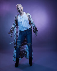 Artistic full-body portrait of Dain August in a glittering blue outfit, showcasing an expressive pose, shot by Ylva Erevall.