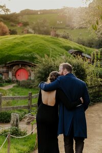 A bride and groom facing away looking at the Hobbtion gardens during their wedding photoshoot with Waikato Photographer Haley Adele Photography
