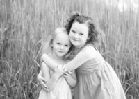 Two sisters hugging outdoors at a Chicago park during family portrait session