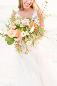Bride holds bouquet in front of her.
