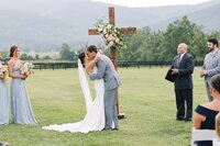 Bride and groom embracing on the vineyard lawn at King Family Vineyard, florals by Flowergirl Cville, Charlottesville wedding florist | Photo by Paige Ryan Photography