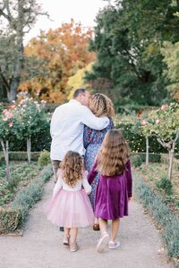 Mother and father embracing while their daughters hold hands behind them at Filoli
