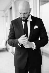 Groom positions his suit sleeves