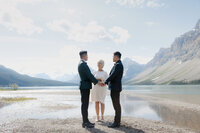 Same sex couple during their lakeside cermeony in banff