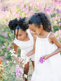 Two sisters looking at sweet pea blooms in Seattle's Discovery Park