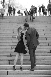 Central park engagement photos, Deborah Zoe Photography. A couple kiss walking up the steps in Central Park.