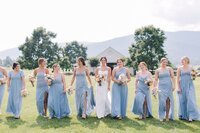 Bridesmaids in dusty blue carrying bouquets designed by Flowergirl Cville at King Family Vineyard, Charlottesville VA | Photo by Paige Ryan Photography