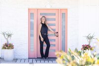 Entrepreneur standing at a modern pink door during a Ventura County brand photography session.