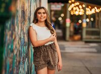 Senior portrait in downtown Mobile, Alabama — leaning against the graffiti wall.