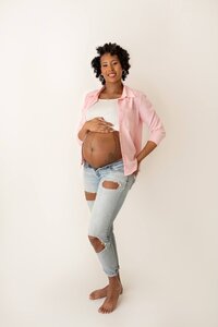 pregnant mom holding baby bump in casual, classic studio maternity photoshoot