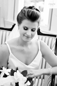 black and white photo of bride looking at flowers