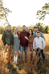 a family poses with their grown children during their fall family photo session in huntsville,texas