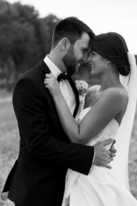 Black and white close-up portrait of bride and groom embracing