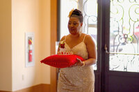 Venice Beach Los Angeles wedding photography of the mother of the groom walking down the aisle carrying a wedding crown, captured in a candid documentary moment with true to life color.
