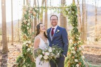Couple portrait under foraged greenery arbor with winter florals by Flowergirl Cville at Indigo House, Afton, VA | Photo by Xiaoqi Li Photography