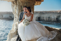 Cyprus Wedding Photography - couple  seated at Cape Greco Sea Caves