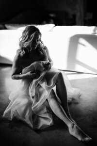 Boudoir experience studio woman seated on floor covering up with silk