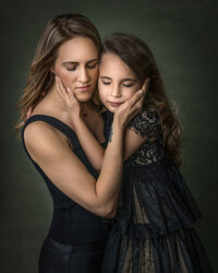Special Mother and Daughter holding each others faces for mommy and me photos in studio in New Jersey.