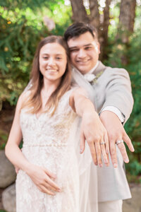 Photo of bride and groom show their rings