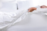 image of woman pulling dreamfit sheets over bed during a commercial product photoshoot by focus creative photographer kassady gibson
