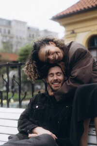Cool and funky couple sitting on a bench in Prague city center - edgy editorial street style photography