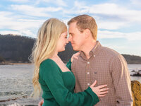 Candid photo of a couple sharing an intimate moment on the beach during a summertime sunset engagement session.