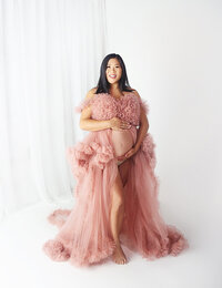 Pregnant women wearing pink maternity glam gown during maternity photoshoot in Mount Juliet Photography studio