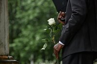 black-man-holding-white-rose-before-placing-flower-2025-03-10-07-49-14-utc