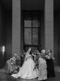 Bride surrounded by bridesmaids adjusting her dress before the ceremony at a Huntsville wedding.