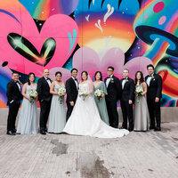 Bridal party stands outside an NYC mural