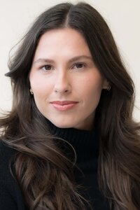 Close-up photo of a stunning woman with long dark hair looking serious