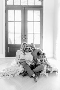 black and white photo of family sitting on floor in their home