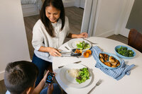 Family dinner being served, with the device app on a phone at the table
