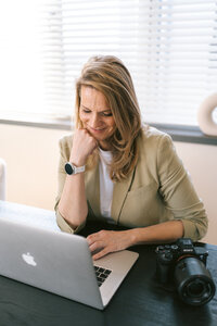 Branding fotografie van fotografe achter laptop aan een tafel