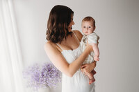 Charleston Mini Sessions - Mother embraces her baby during Mother's Day Mini Session at Holy City Babies in Charleston, SC.