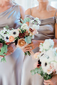 Bridesmaid holds her bouquet with white flowers and dried oranges
