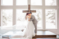 Bride and Groom first kiss in the chapel at The Barn At Paradise Place captured by Graceful Ray Photography in Fort Worth Texas