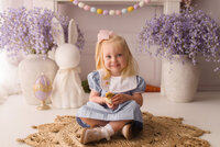 Little girl holds live baby chics during Easter Mini Session at Holy City Babies Portrait Studio in Charleston, SC.